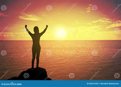 Silhouette Of Winning Success Woman At Sunset Or Sunrise Standing And Raising Up Her Hand In
