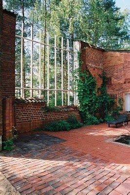 An Outdoor Patio With Brick Walls And Lots Of Greenery On The Side Of It