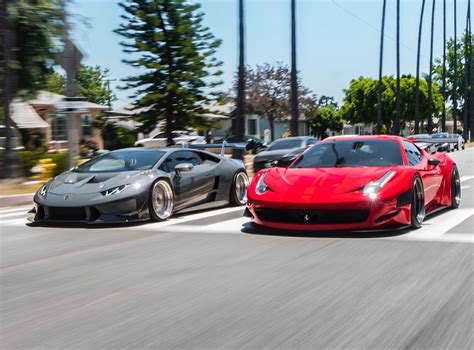 Two Red Sports Cars Driving Down The Road Next To Each Other In Front