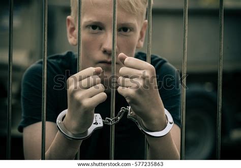 Handcuffed Teenage Boy Behind Bars Prison Foto Stock 577235863