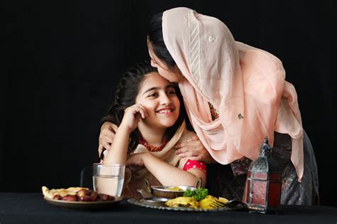 Adorable Pakistani Muslim Girl With Hijab Sits At Kitchen Table With Traditional Islamic Halal