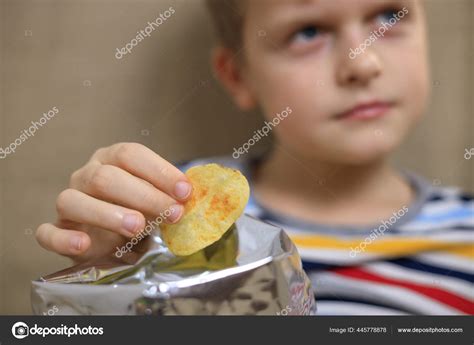 Niño Sentado En El Sofá Comiendo Patatas Fritas Del Paquete