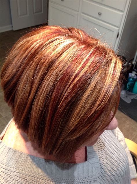 copper base red lowlights and chunky blonde highlights color in red hair with blonde