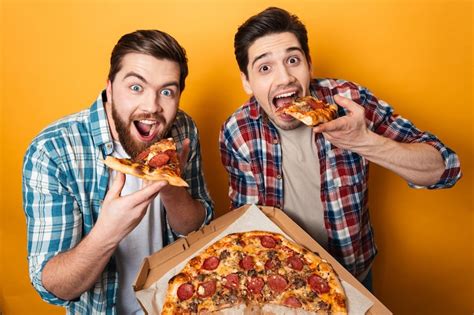 Premium Photo Portrait Of A Two Hungry Young Men Eating Pizza