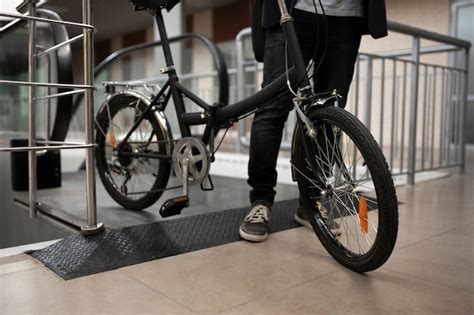 Free Photo Young Man With Folding Bike On Escalator