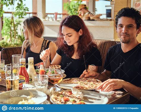 Cheerful Young Friends Enjoying Food And Having Fun Together In The