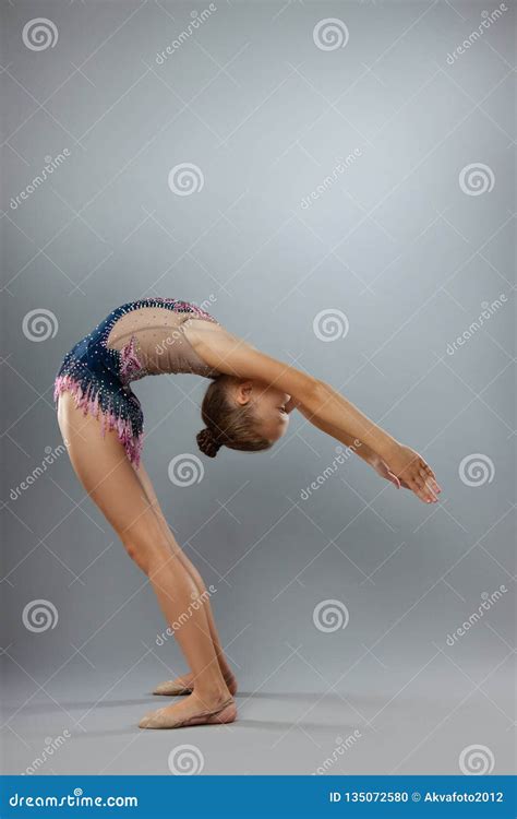 beautiful flexible gymnast in sports outfit performs an element of rhythmic gymnastics stock