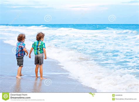 Two Little Kids Boys Looking On Sunset On The Beach Of