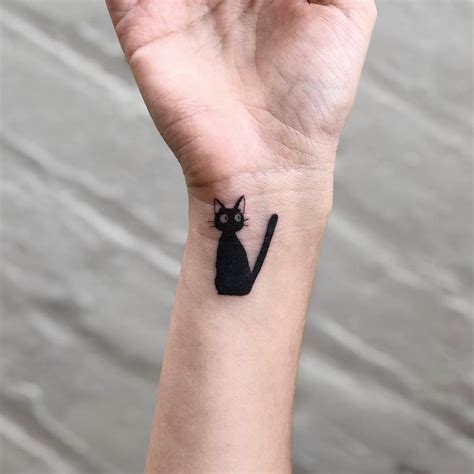 Jiji Tattoo Located On The Wristl Cartoon Style