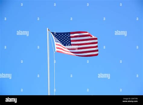 American Flag Waving Against Blue Sky Stock Photo Alamy