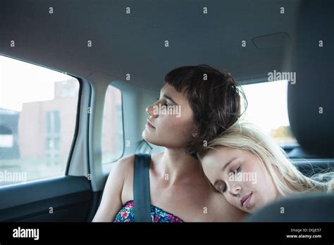 Women In Backseat Of Car One With Head On Friend S Shoulder Stock