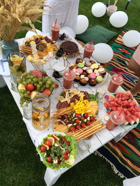 A Table Filled With Lots Of Food On Top Of A Grass Covered Field Next