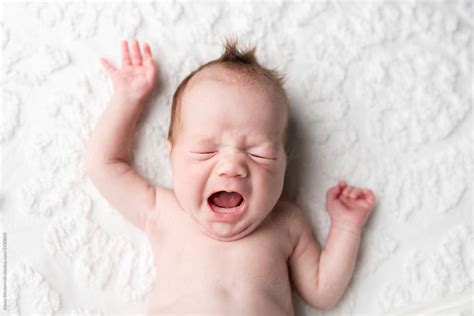 A Baby With A Big Yawn Laying On A Chenille Blanket By Stocksy