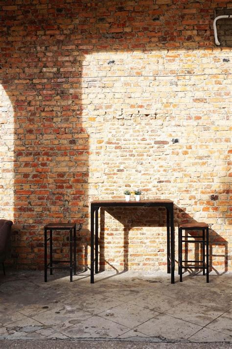 Premium Photo A Brick Wall With A Table And Two Chairs In Front Of It