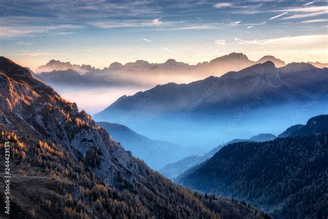 Mountains In Fog At Beautiful Sunset In Autumn In Dolomites Italy