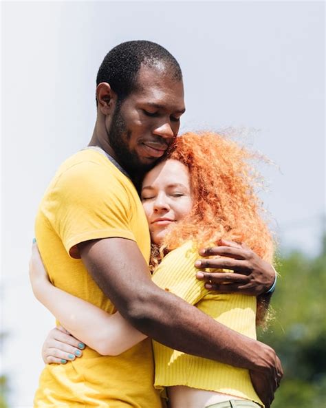 Side View Of Interracial Couple Hugging Free Photo