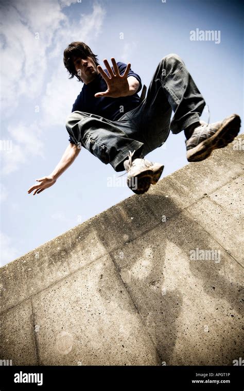 Man Doing Parkour Jumping Down From A Wall Stock Photo Alamy
