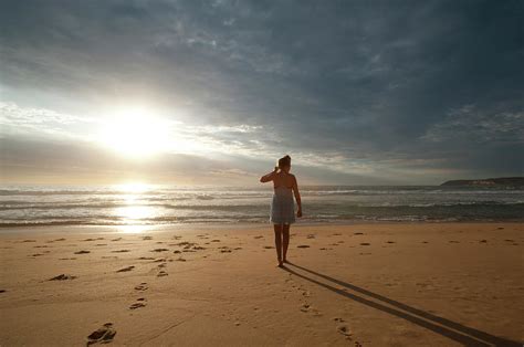 Woman Walking Along The Beach Photograph By Courtneyk