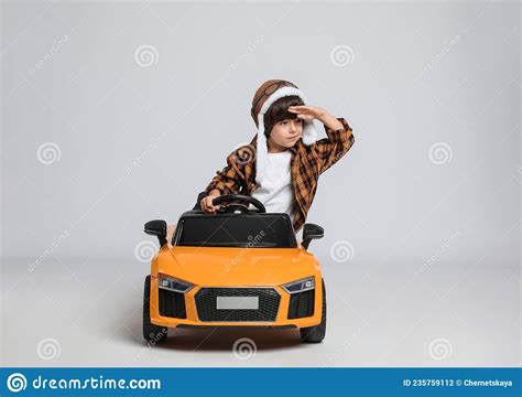 Cute Little Boy In Pilot Hat Driving Children`s Electric Toy Car On