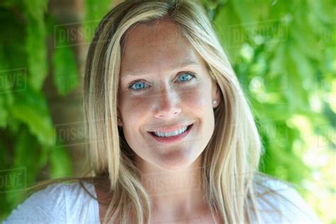Portrait Of Mature Woman With Blonde Hair And Blue Eyes Stock Photo Dissolve