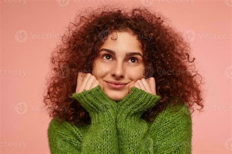 portrait of attractive adult girl with ginger curly hair wearing green turtleneck sweater and