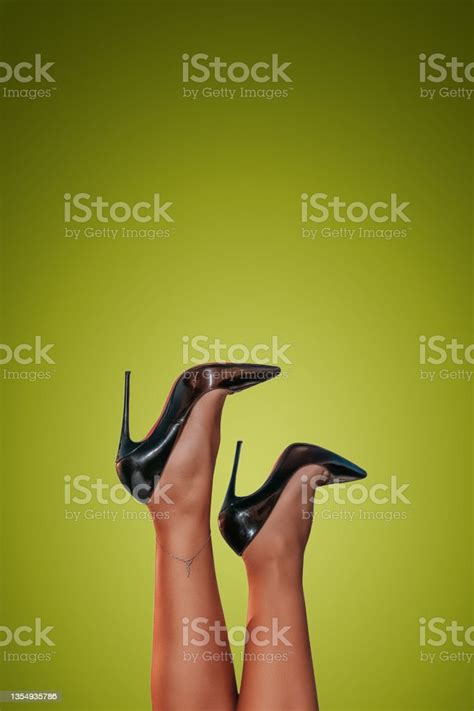 Beautiful Female Legs Wearing Black High Heels Over Bright Background