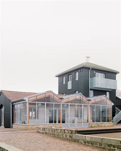 A House With Glass Walls On The Side Of It And Stairs Leading Up To It