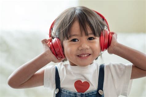Happy Asian Child Enjoy Listening To Music With Headphones Stock Photo