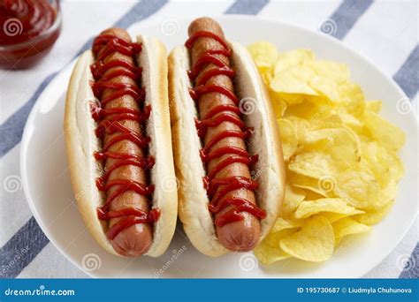 Tasty American Hot Dog With Potato Chips On A White Plate Side View