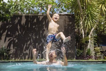 Father And Son Having Fun In Swimming Pool Stock Photo