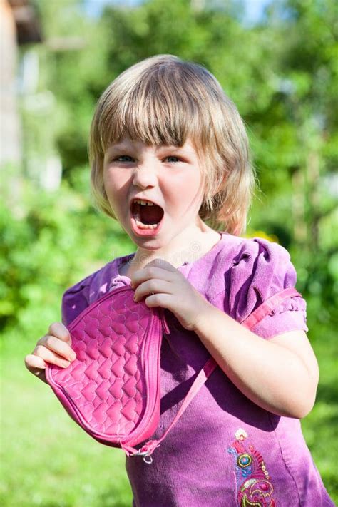 Little Caucasian Girl Screaming With Small Pink Bag In Hands Wearing