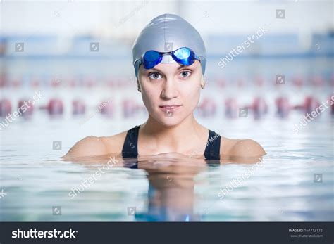 Portrait Of A Female Swimmer Wearing A Swimming Cap And Goggles In Blue