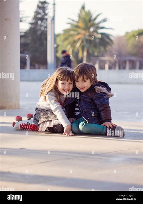 Spain Girona Smiling Little Boy And Girl Sitting Side By Side On The