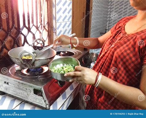 Indian Beautiful Village Women Cooking Vegetable In Her Kitchen Stock