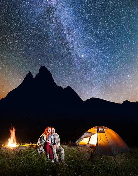 Camping Couple Looking At Mountain And Tent In Wild Outdoors Stock