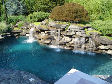 Often built with rocks or boulders (real and faux) as part of naturalistic pool design, waterfalls are one of the most popular water features when paired with swimming pools. Pool Landscape Patio Waterfall Natural Swimming ...