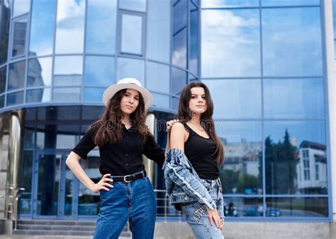 Two Young Brunette Girls Wearing Casual Jeans Attire Standing In