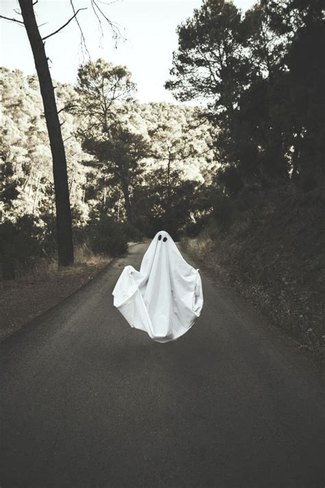 Free Photo Human In Ghost Suit Levitating On Countryside Route