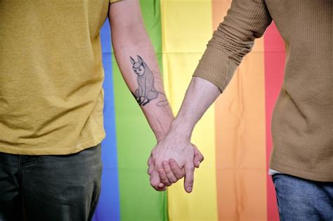 premium photo homosexual men holding hands when standing against rainbow pride flag