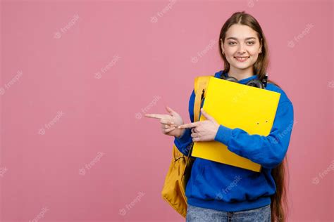 Free Photo Pretty Schoolgirl Standing With Folder Looking At Camera