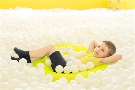 Child Boy Lying With Closed Eyes In Yellow Inflatable Swimming Ring In