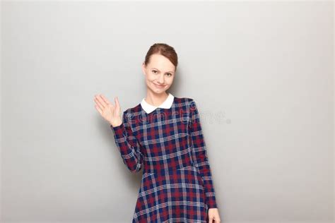 Portrait Of Happy Pretty Girl Waving Her Hand And Saying Hello Stock