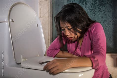 Young Drunk Or Pregnant Asian Woman Vomiting And Throwing Up In Toilet