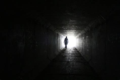 Person Walking Inside Dark Tunnel With White Light On Far Distanc Hd