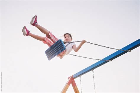 Young Girl Flying High On A Swing Looking At Camera By Lea Csontos