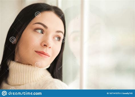 Portrait Of A Brunette Girl At The Window With Reflection Closeup