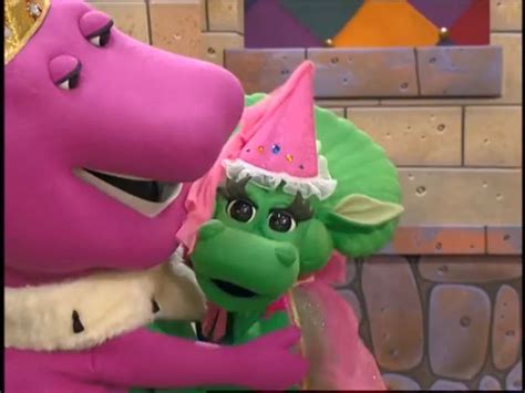The Pink And Green Dragon Are Hugging Each Other In Front Of A Brick Wall