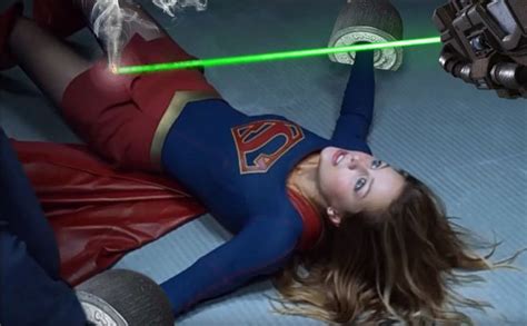 A Woman Laying On The Ground With A Green Light Saber In Her Hand And Another Person Behind Her