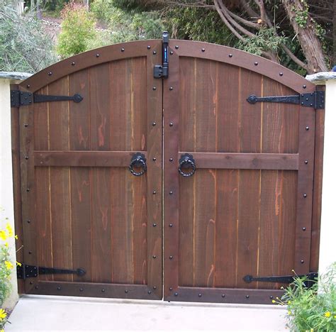 A Large Wooden Gate With Metal Hardware On Its Sides And Two Doors Open