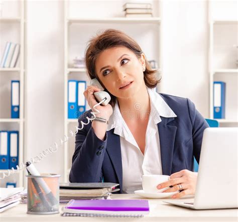 middle aged female employee sitting at the office stock image image of coffee businesswoman